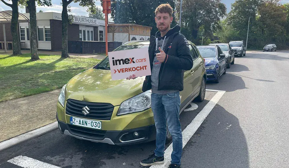 Verkoper met Imex Cars ‘VERKOCHT’ bord bij verkochte auto – verkoop je auto in België